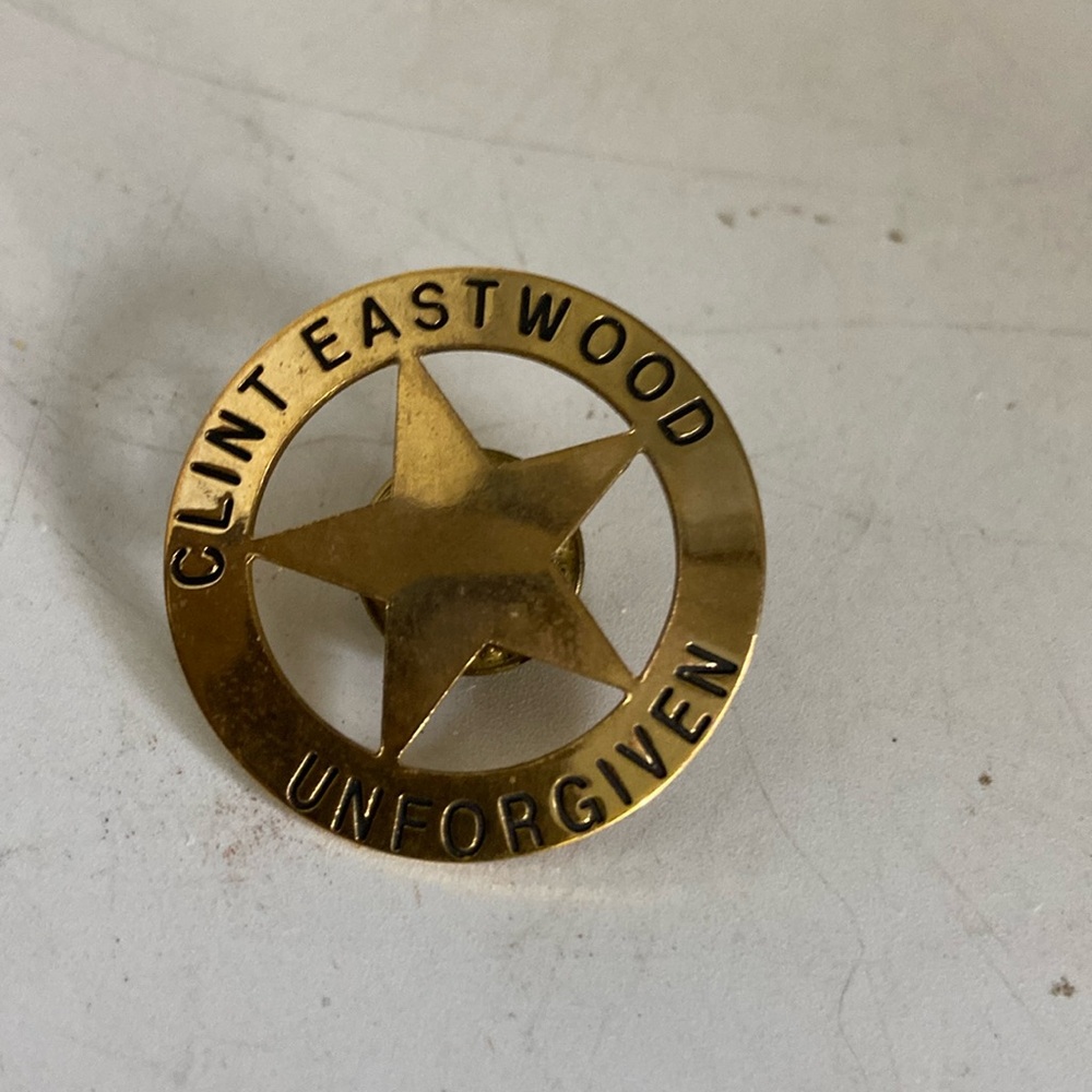 Clinton Eastwood pin re movie ‘Unforgiven a star within a circle gold color